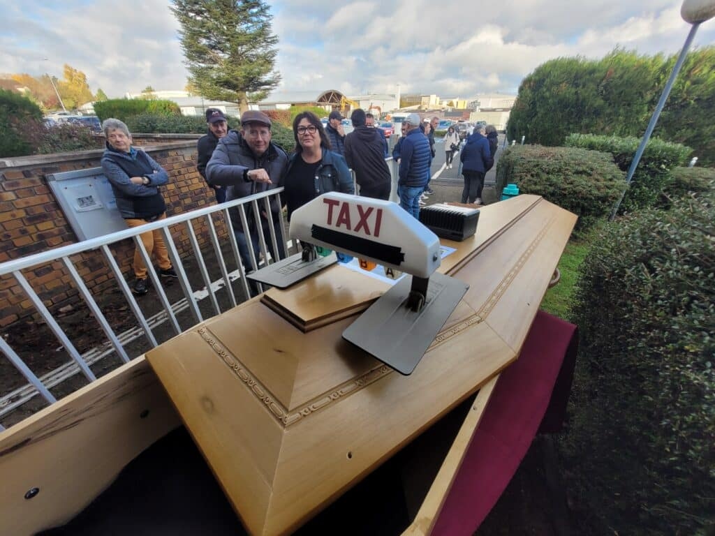 The taxi drivers deposit their agreement in a coffin