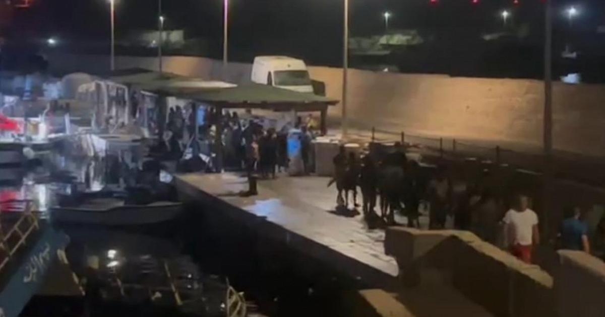Overlevenden van de schipbreuk bij Lampedusa komen aan bij de haven van Favarolo.